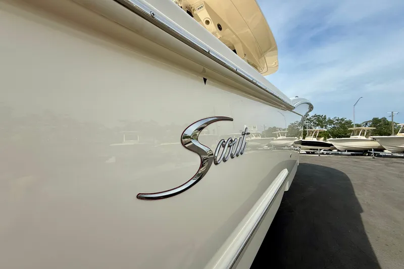 Slide: The Image of 2026 Scout 400 LXF Li-Ion boat cruising on open water under clear skies. - 2