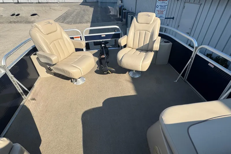 Slide: The Image of 2015 Bennington 24 SFX boat interior with beige seating and steering console. - 11