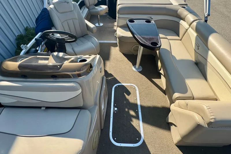 Slide: The Image of 2015 Bennington 24 SFX boat interior with beige seating and steering console. - 15