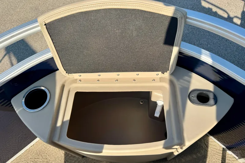 Slide: The Image of Open storage compartment on a 2015 Bennington 24 SFX boat with cup holders. - 16