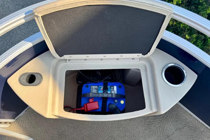 Slide: The Image of 2015 Bennington 24 SFX boat storage compartment with battery and cup holder. - 17