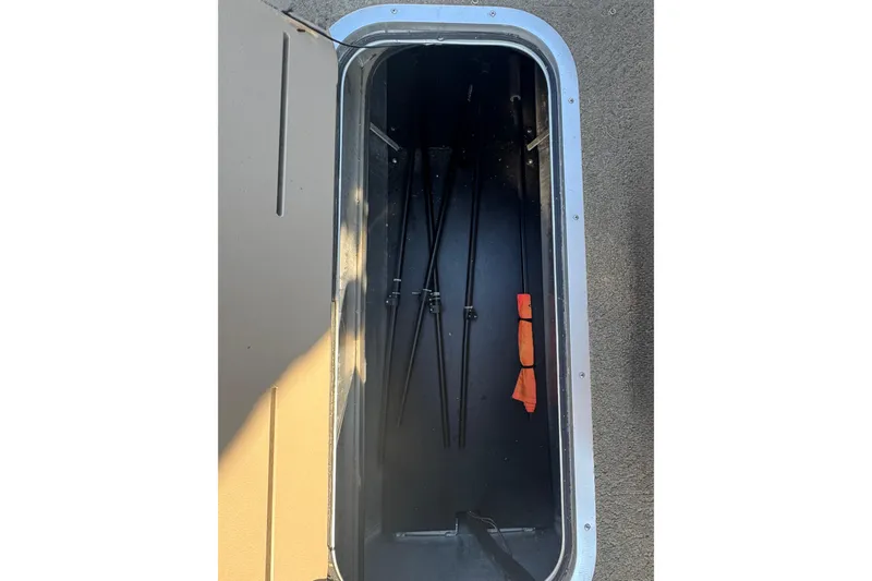 Slide: The Image of Storage compartment of a 2015 Bennington 24 SFX boat with fishing rods and gear. - 23