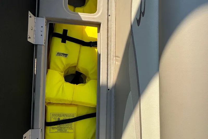 Slide: The Image of Yellow life jackets stored on a 2015 Bennington 24 SFX boat. - 24