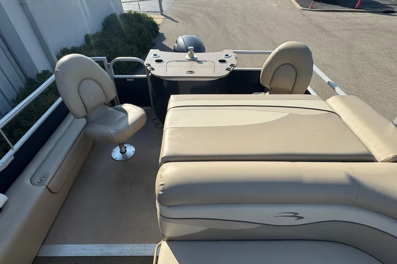 Slide: The Image of 2015 Bennington 24 SFX boat interior with beige seating and helm station. - 25