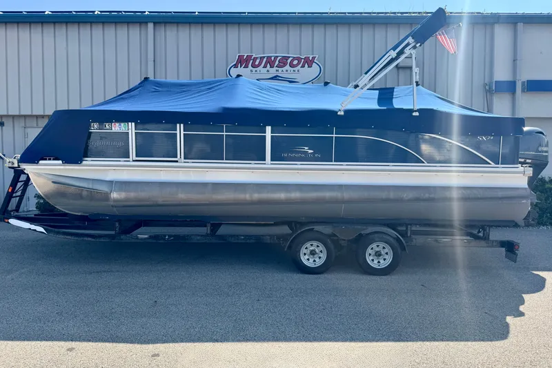Slide: The Image of 2015 Bennington 24 SFX pontoon boat with blue cover on trailer. - 3