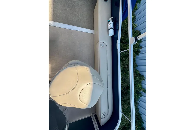 Slide: The Image of 2015 Bennington 24 SFX boat interior with beige seating and a mounted fire extinguisher. - 9