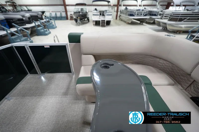 Slide: The Image of 2026 Bennington 20 SLJ pontoon boat interior with seating and table, displayed in showroom. - 18
