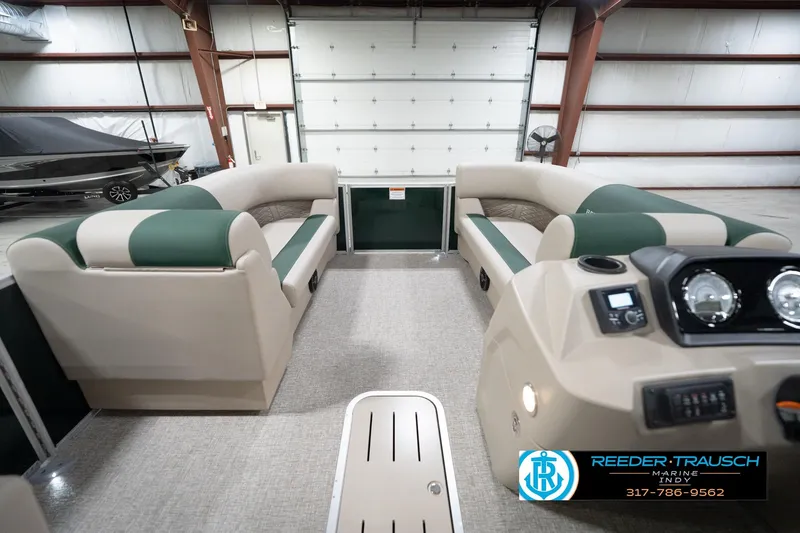 Slide: The Image of 2026 Bennington 20 SLJ pontoon boat interior with plush seating in a showroom. - 20