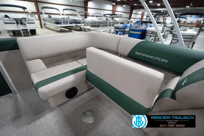 Slide: The Image of 2026 Bennington 20 SLJ pontoon boat interior with green and beige seating in showroom. - 30