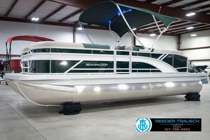 Slide: The Image of 2026 Bennington 20 SLJ pontoon boat in showroom with canopy and sleek design. - 4