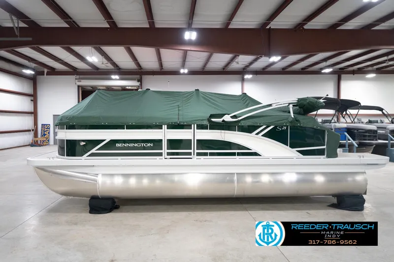 Slide: The Image of 2026 Bennington 20 SLJ pontoon boat with green cover in indoor showroom. - 60