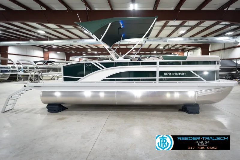 Slide: The Image of 2026 Bennington 20 SLJ pontoon boat in indoor showroom with green canopy. - 7
