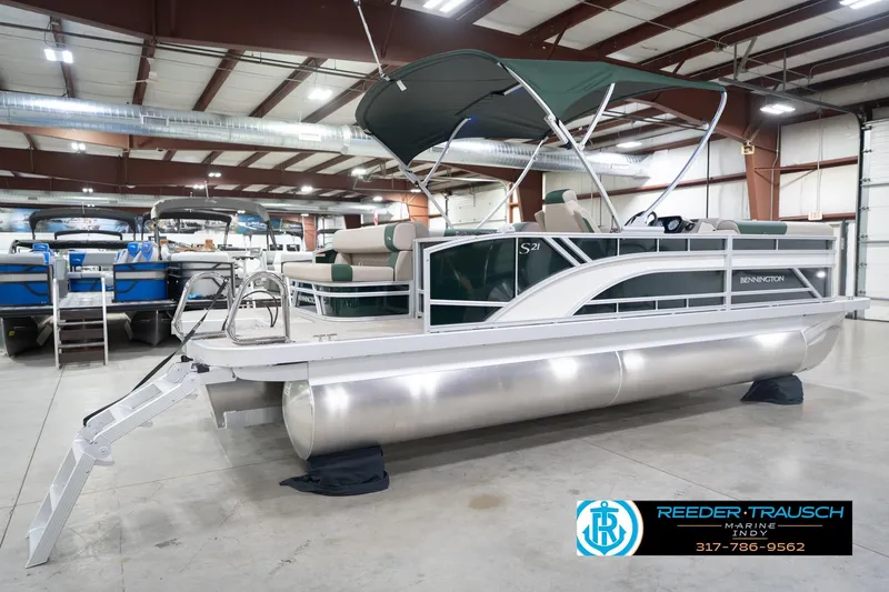 Slide: The Image of 2026 Bennington 20 SLJ pontoon boat in showroom with canopy and ladder. - 8