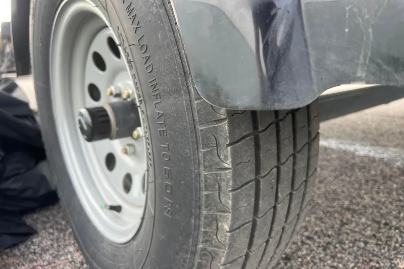 Slide: The Image of Close-up of a 2023 Alumacraft Voyageur 175 SC trailer tire on asphalt. - 13
