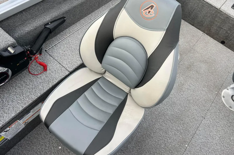 Slide: The Image of 2023 Alumacraft Voyageur 175 SC boat seat, gray and white design, with control panel nearby. - 20