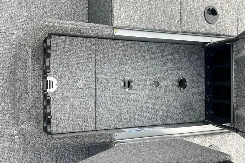 Slide: The Image of 2023 Alumacraft Voyageur 175 SC boat interior with gray carpeted storage compartments. - 28