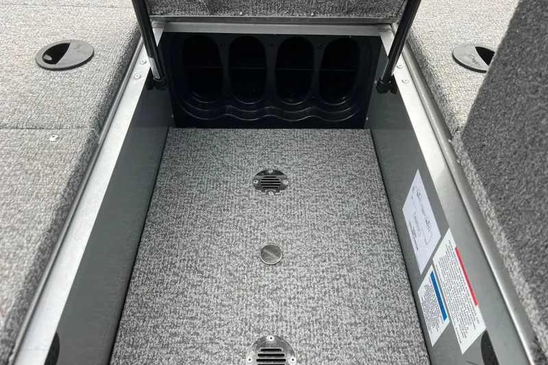 Slide: The Image of Interior storage compartment of 2023 Alumacraft Voyageur 175 SC boat, featuring carpeted flooring. - 30