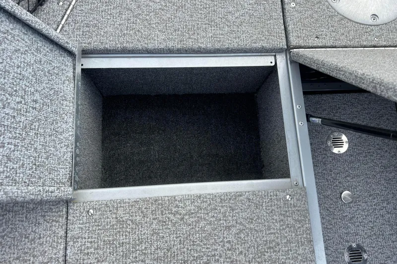 Slide: The Image of 2023 Alumacraft Voyageur 175 SC boat storage compartment with gray carpeted interior. - 31
