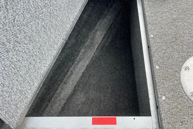 Slide: The Image of 2023 Alumacraft Voyageur 175 SC boat storage compartment with carpeted interior. - 32