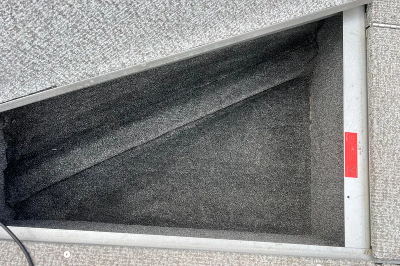 Slide: The Image of Storage compartment in 2023 Alumacraft Voyageur 175 SC boat, featuring carpeted interior. - 33