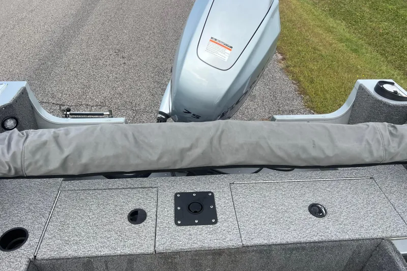 Slide: The Image of 2023 Alumacraft Voyageur 175 SC boat interior with motor, gray upholstery, and storage compartments. - 40