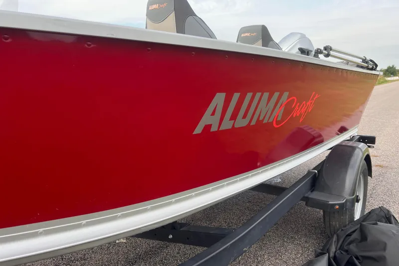 Slide: The Image of 2023 Alumacraft Voyageur 175 SC boat with red exterior on a trailer. - 51