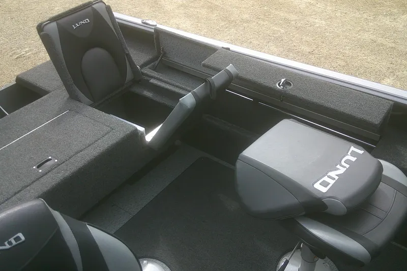 Slide: The Image of 2022 Lund 1675 Impact XS Sport boat interior with cushioned seating and storage compartments. - 13