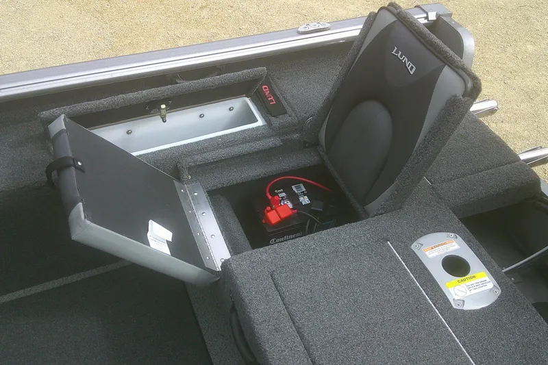 Slide: The Image of 2022 Lund 1675 Impact XS Sport boat interior with storage compartment and battery. - 14