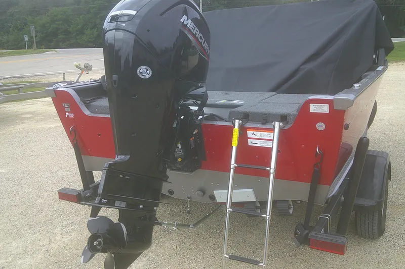 Slide: The Image of 2022 Lund 1675 Impact XS Sport boat with Mercury outboard motor and ladder, parked on trailer. - 16