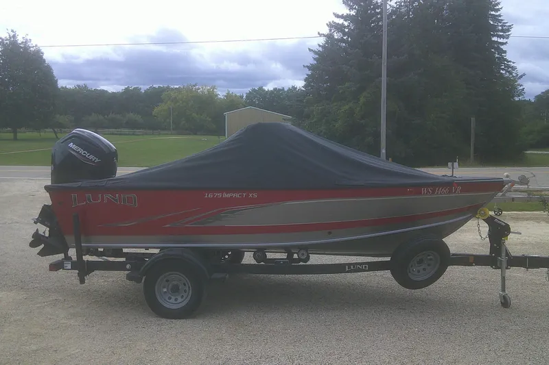 Slide: The Image of 2022 Lund 1675 Impact XS Sport boat on trailer, covered, with Mercury outboard motor. - 17