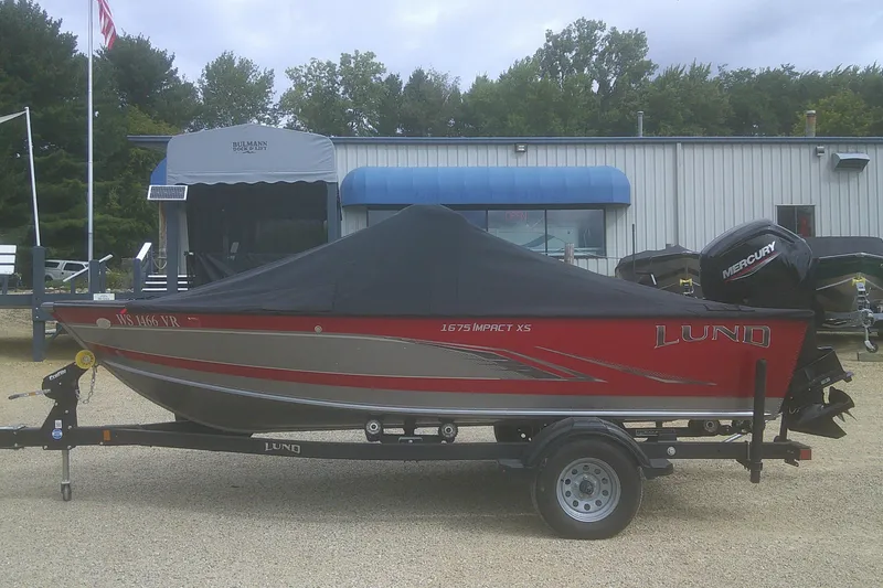 Slide: The Image of 2022 Lund 1675 Impact XS Sport boat on trailer, covered, with Mercury outboard motor. - 18