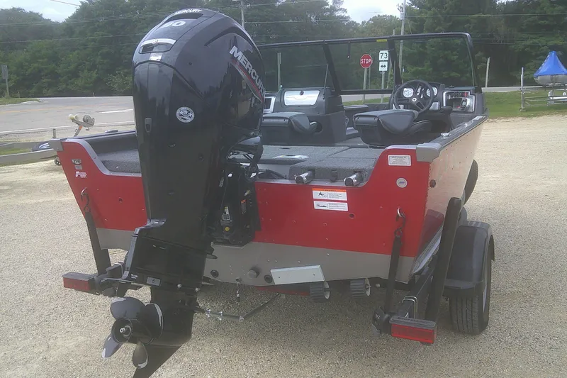 Slide: The Image of 2022 Lund 1675 Impact XS Sport boat with Mercury outboard motor, parked on a trailer. - 3