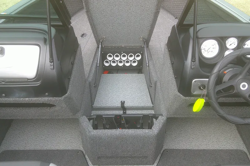 Slide: The Image of 2022 Lund 1675 Impact XS Sport boat interior with rod storage and dashboard controls. - 6