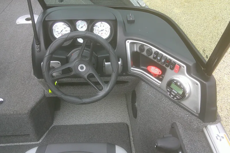 Slide: The Image of 2022 Lund 1675 Impact XS Sport boat dashboard with steering wheel and control panel. - 7