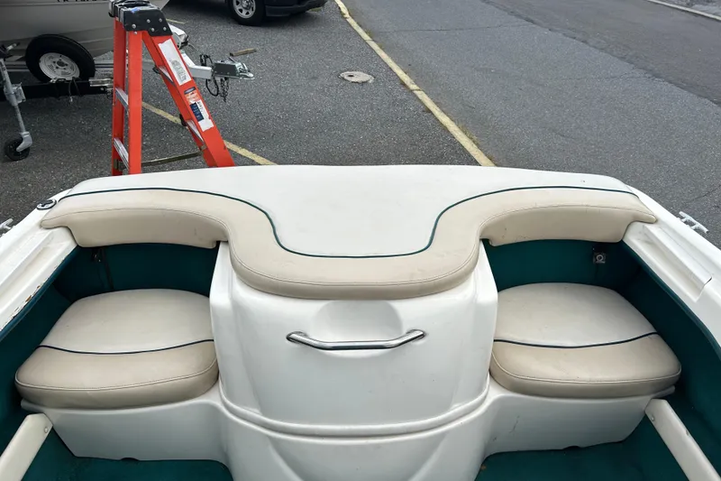 Slide: The Image of 1998 Sea Ray 180 Bow Rider interior with white and teal seating. - 7