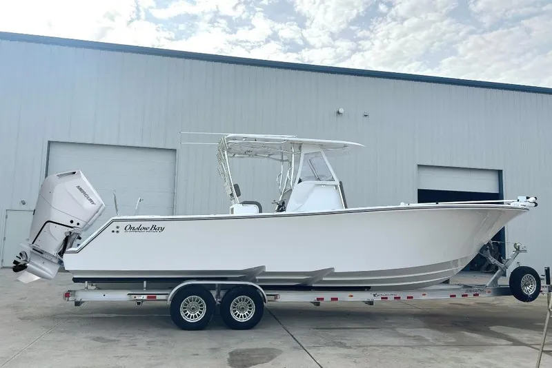 The Image of 2024 Onslow Bay 33 Tournament boat on trailer outside a warehouse. - 1