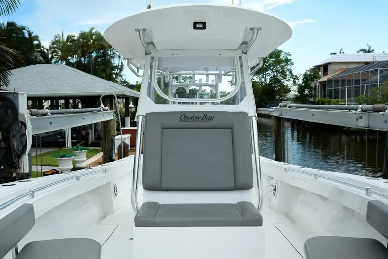 Slide: The Image of 2024 Onslow Bay 33 Tournament boat interior with seating, docked by a canal. - 12