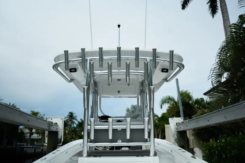 Slide: The Image of 2024 Onslow Bay 33 Tournament boat with T-top and rod holders, docked near palm trees. - 17