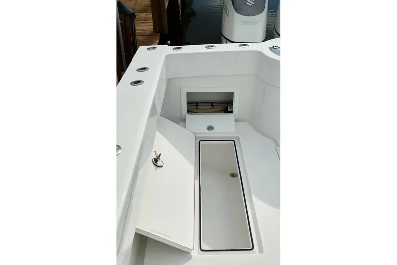 Slide: The Image of 2024 Onslow Bay 33 Tournament boat deck with storage compartments and rod holders. - 6