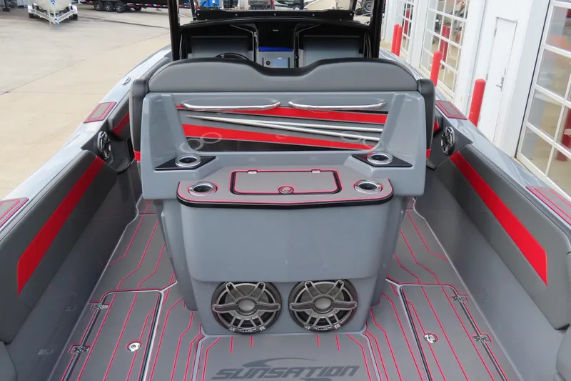 Slide: The Image of 2025 Sunsation 32CCX boat interior with sleek gray and red design, featuring cup holders and speakers. - 13