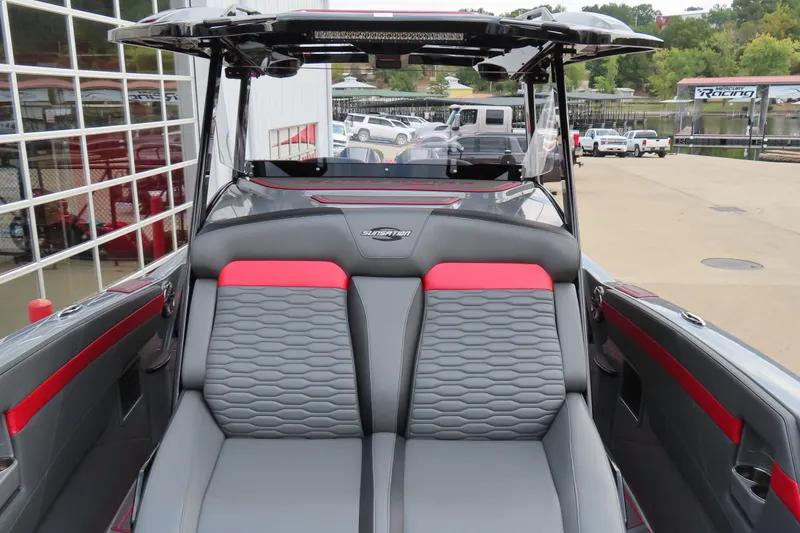 Slide: The Image of 2025 Sunsation 32CCX boat interior with gray and red seating, dockside view. - 21