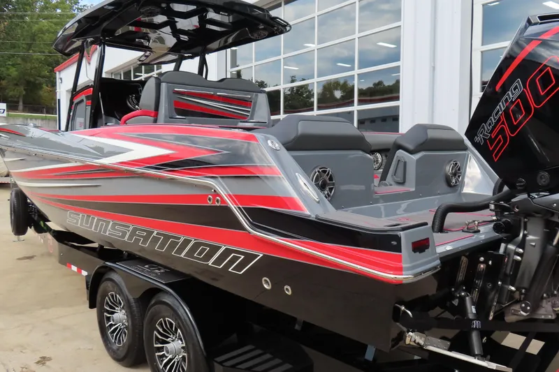 Slide: The Image of 2025 Sunsation 32CCX powerboat with sleek red and gray design, docked outdoors. - 4