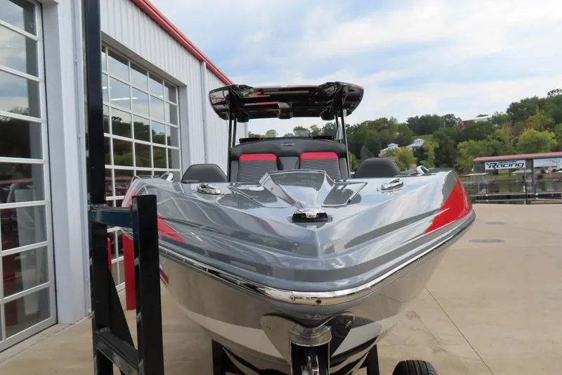 Slide: The Image of 2025 Sunsation 32CCX boat with sleek design, parked outdoors near a modern building. - 7