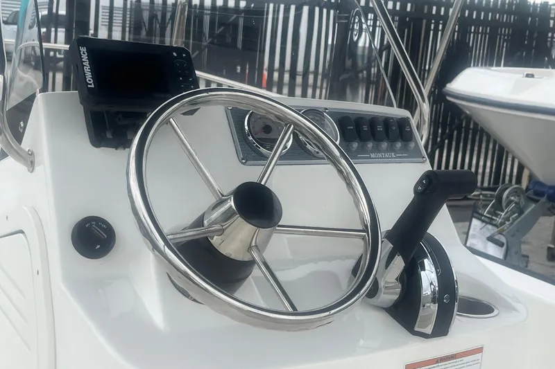 Slide: The Image of 2022 Boston Whaler 170 Montauk helm with steering wheel and controls. - 14