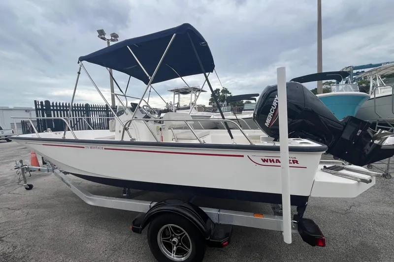 Slide: The Image of 2022 Boston Whaler 170 Montauk boat with canopy and Mercury engine on trailer. - 2