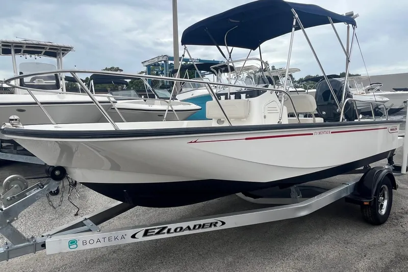 Slide: The Image of 2022 Boston Whaler 170 Montauk boat on trailer, featuring sleek design and canopy. - 5