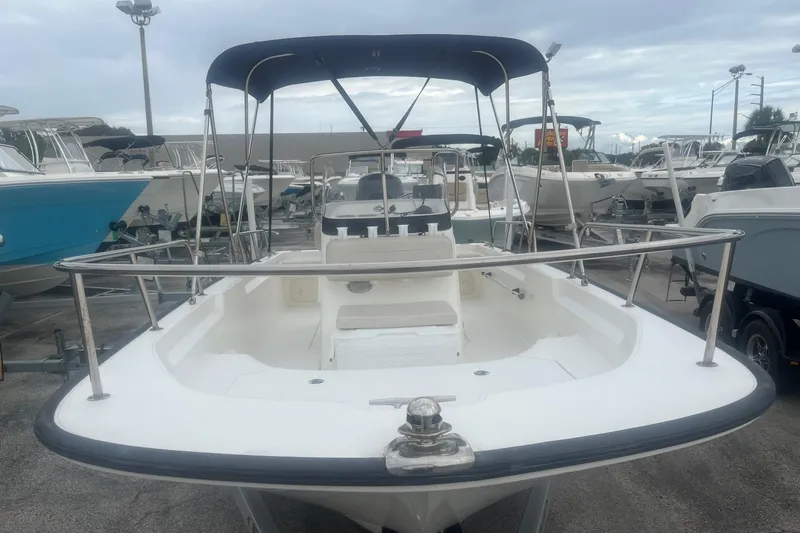 Slide: The Image of 2022 Boston Whaler 170 Montauk boat with canopy, docked among other boats. - 7