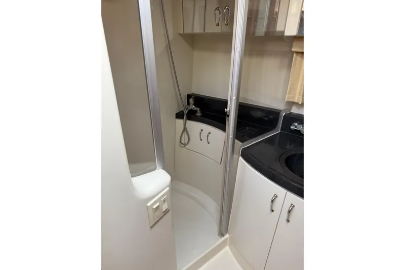 Slide: The Image of 2003 Carver 360 Sport Sedan bathroom with shower, sink, and storage cabinets. - 18
