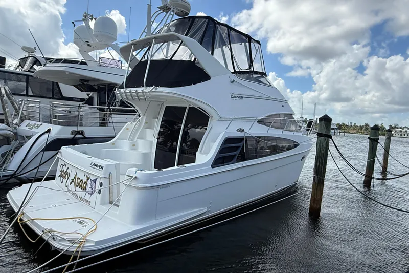 Slide: The Image of 2003 Carver 360 Sport Sedan yacht docked at marina under cloudy sky. - 2