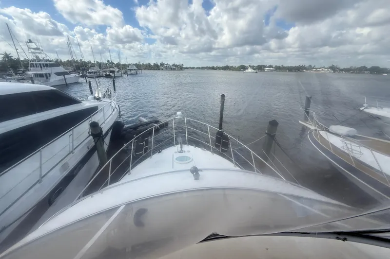 Slide: The Image of 2003 Carver 360 Sport Sedan docked at marina, surrounded by other boats under cloudy sky. - 8